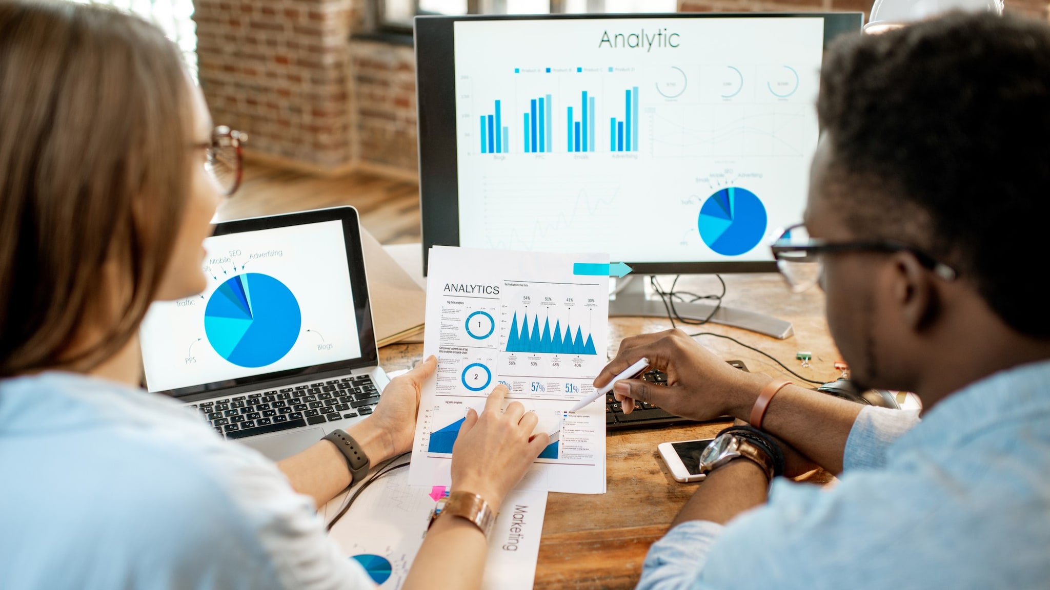 Two people reviewing graphic chart data