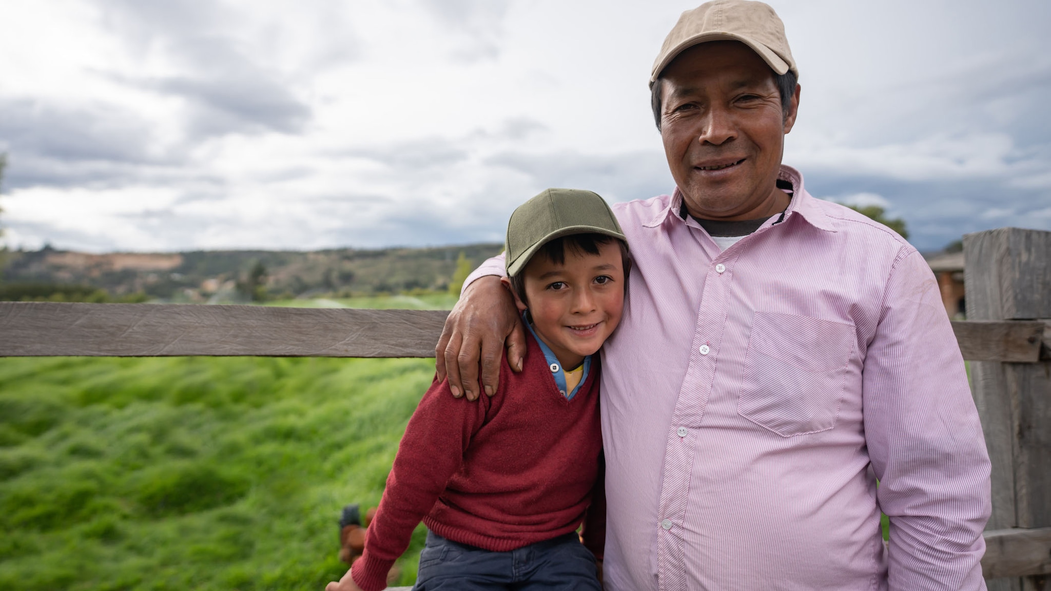 Father and son smiling for a picture outside.