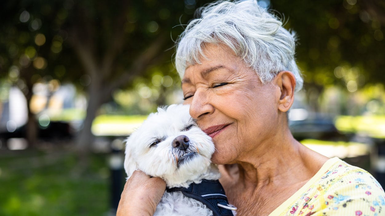 A woman holding a puppy outdoors