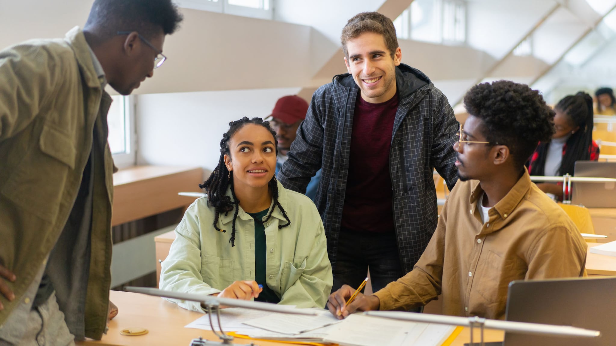 A multiracial group of undergraduates are talking with each other after a class at university