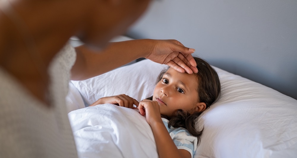 Worried mother checking daughter temperature