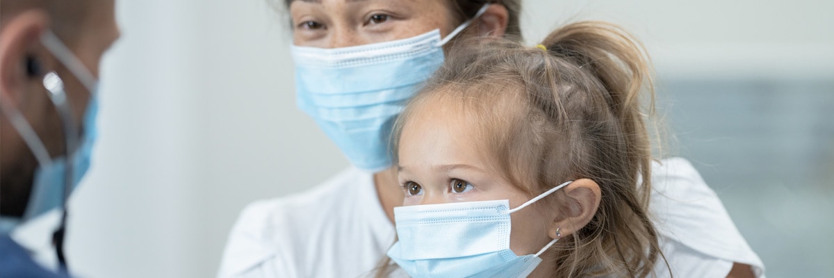 Healthcare professional talking with mother and daughter