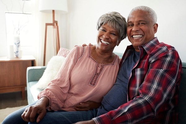 Senior Couple Relaxing On Sofa At Home