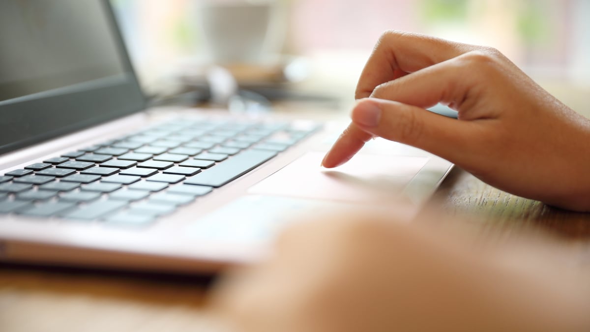 A public health professional typing on their laptop.