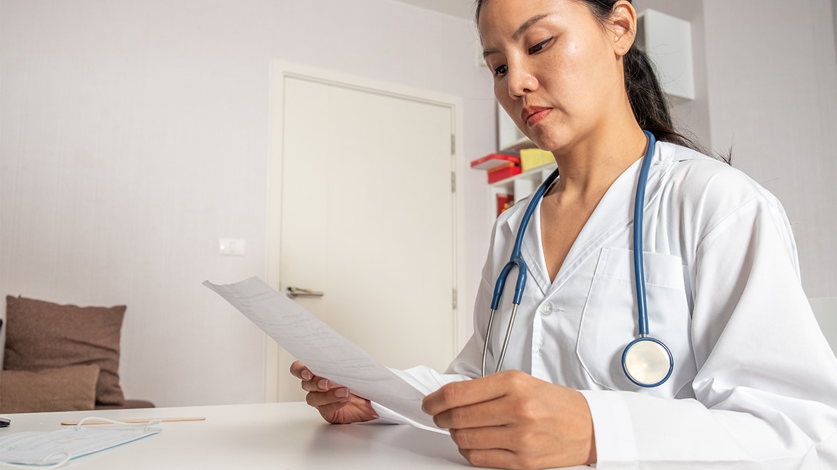 A doctor reading a prescription for a patient.