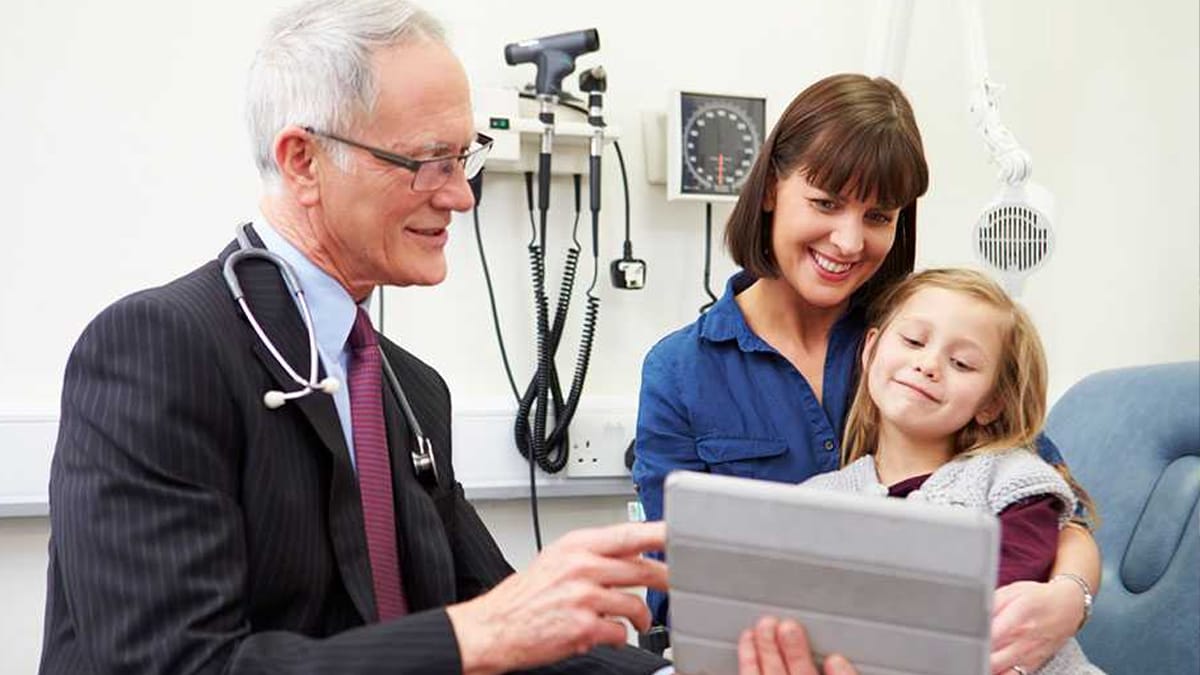 Male doctor meeting with mother and her daughter