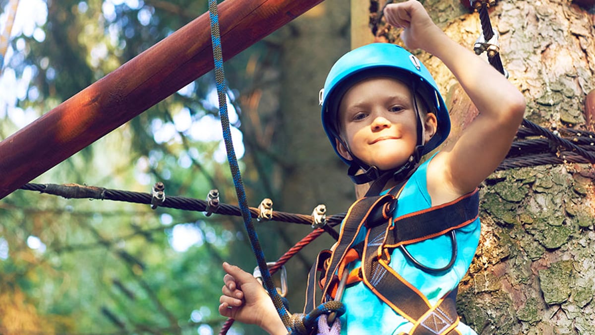 kid in blue helmet completing obstacle course