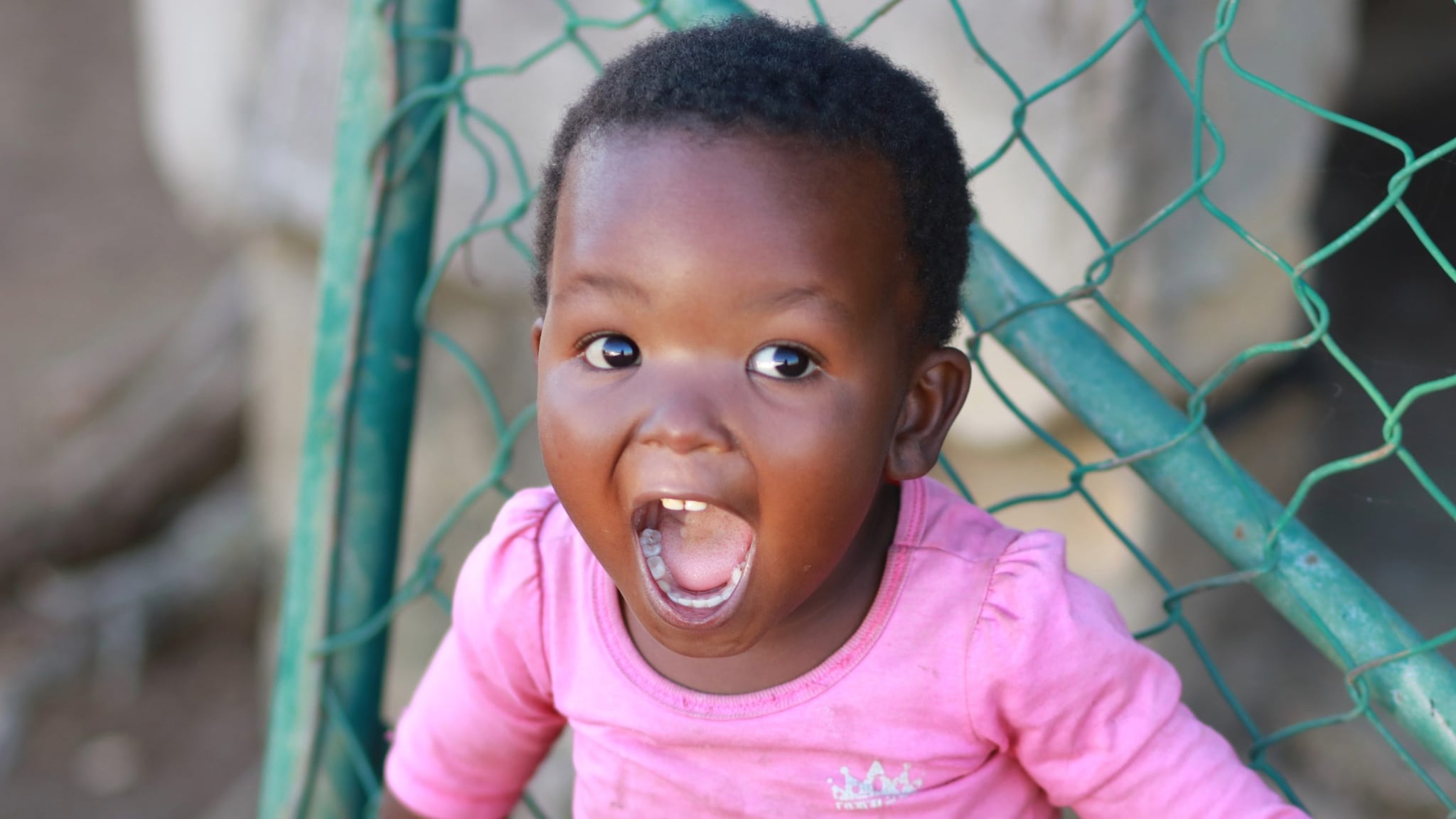 Little girl smiling with a pink shirt on