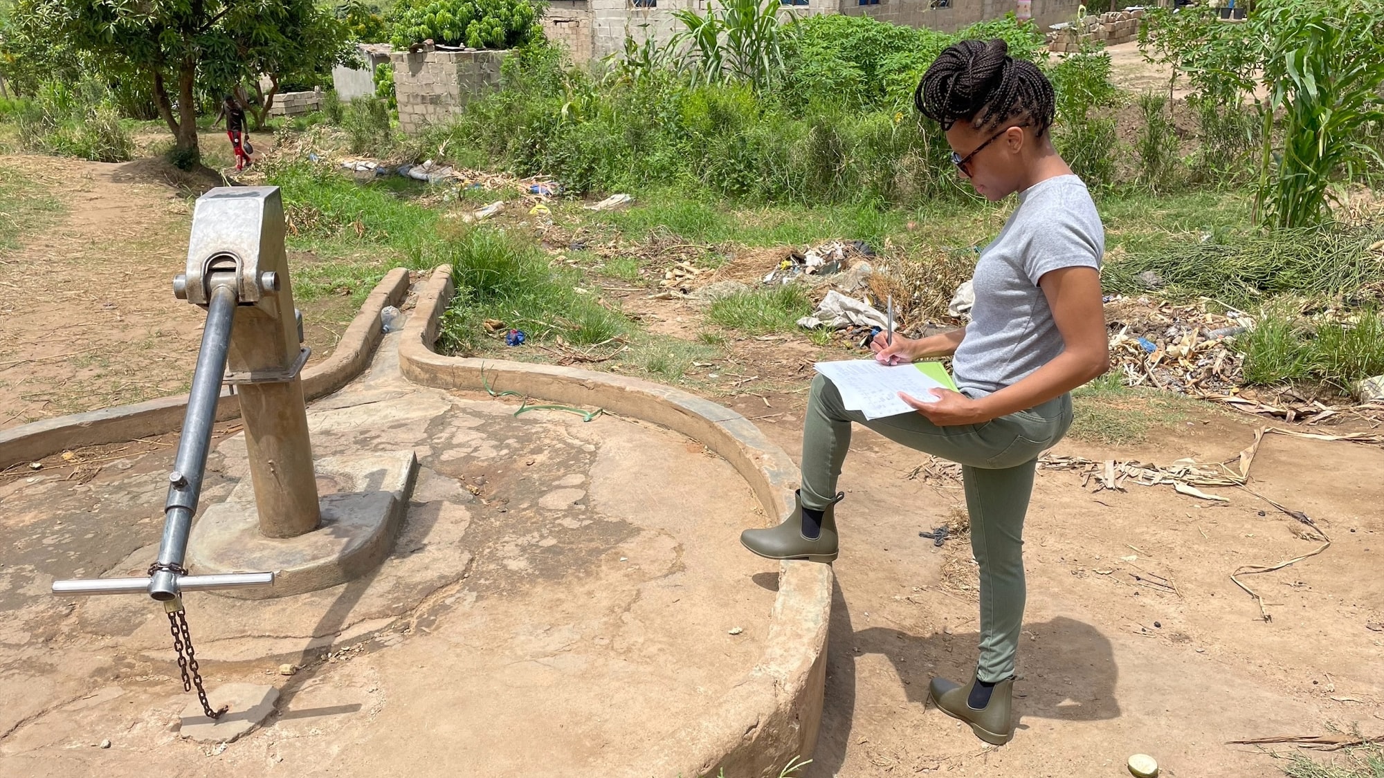 Dr. Frederica Lamar completing a Sanitary Inspection Form for a hand pump well