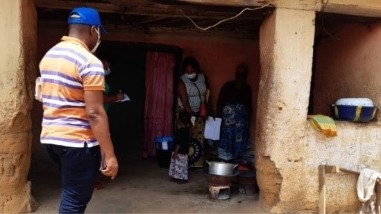 An FETP resident looking for Ebola contacts standing outside a home