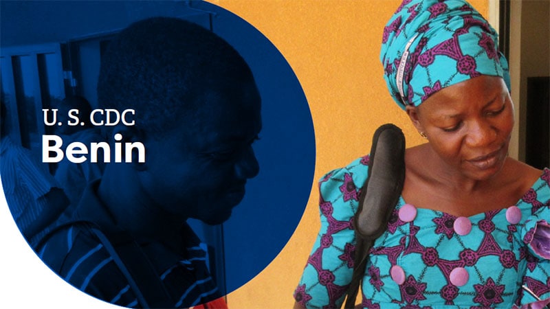 A woman in colorful traditional attire interacts with a man in Benin, West Africa.