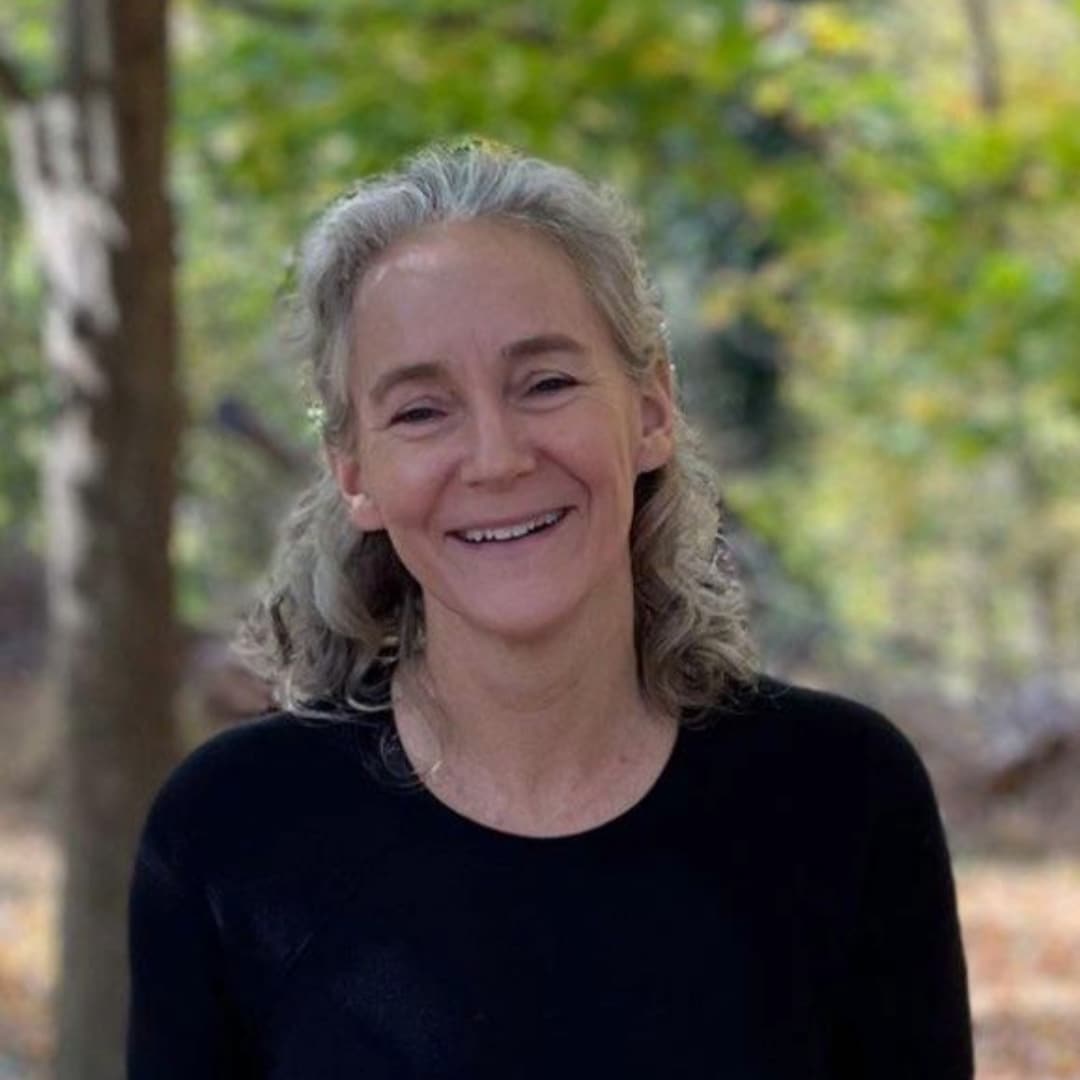 A woman with shoulder length hair, wearing a black shirt.