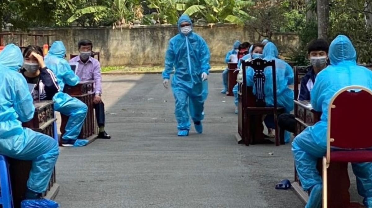 Worker walks outside an outside clinic dressed in blue PPE.