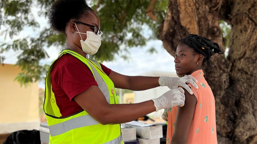 Healthcare worker vaccinates teen.