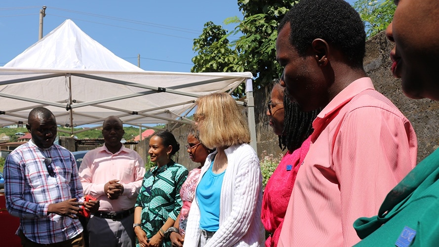 A group of health officials gather and talk outside a local school where health workers are holding a vaccine event for students.