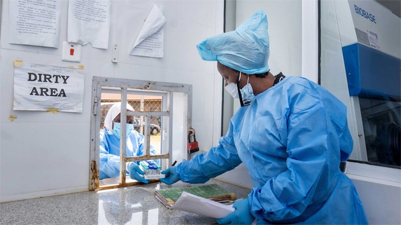 Woman in personal protective equipment at a dispensing window located at the Yusuf Dan Tsoho Memorial Hospital.