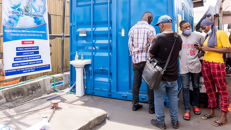 Four people standing beside COVID-19 vaccination site