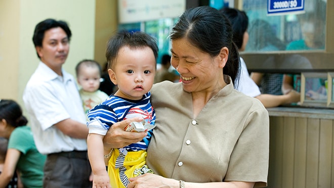 Mother holding child and smiling.