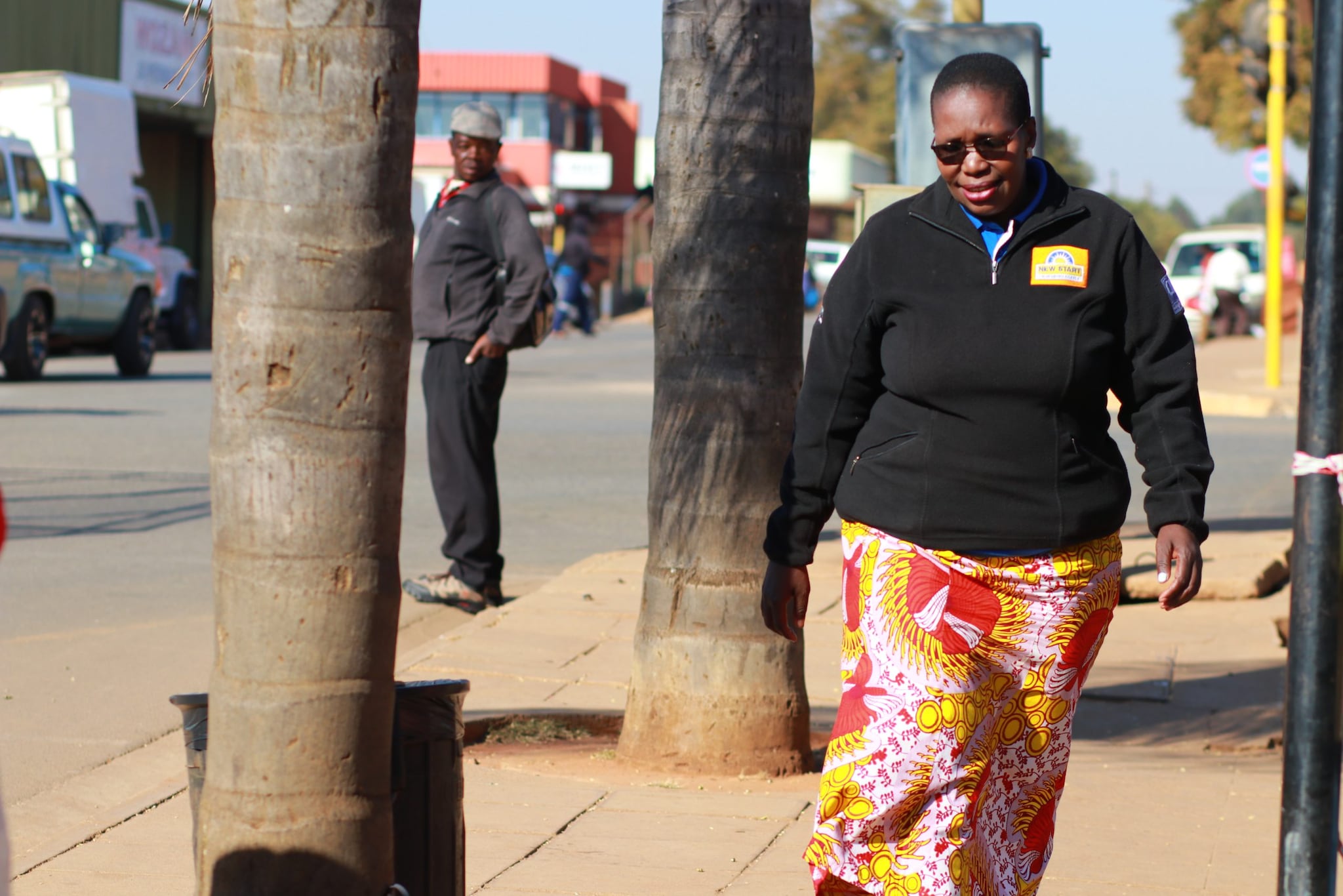 Woman walks on a sidewalk in Eswatini.