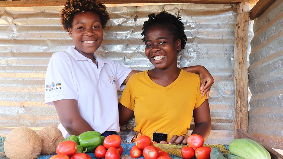 2 young women standing at a fruit stall in Mozambique.