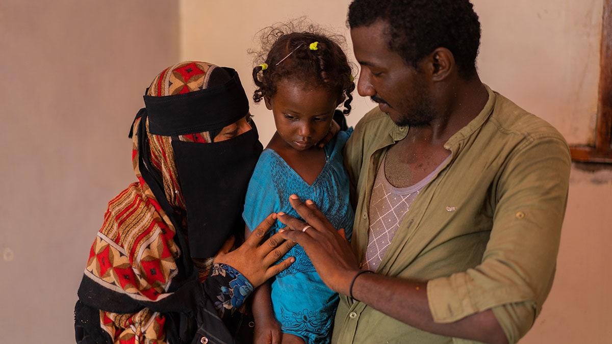 A Yemeni couple hold their daughter.