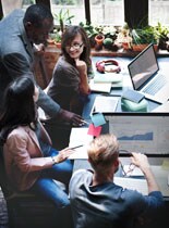 people working around a table with computers