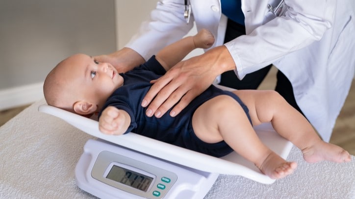 Baby on scales in a health care setting.