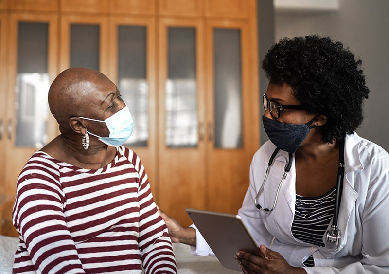 Health care provider talking to patient. Provider’s hand on patient’s arm