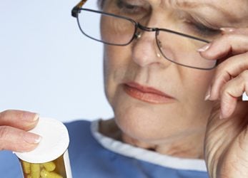 Senior adult reading a pill bottle.