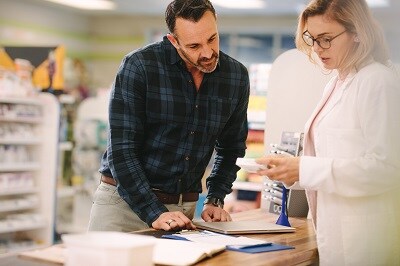 Pharmacist explaining information to customer