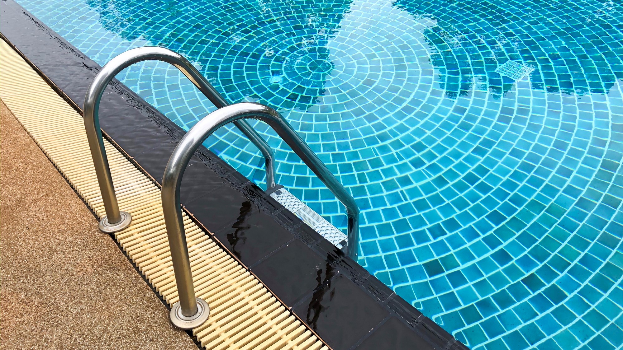 Close up of ladder leading into pool deep end.