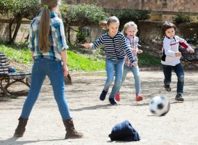 Young kids playing street football outdoors.