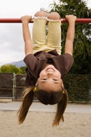 girl hanging on monkey bars