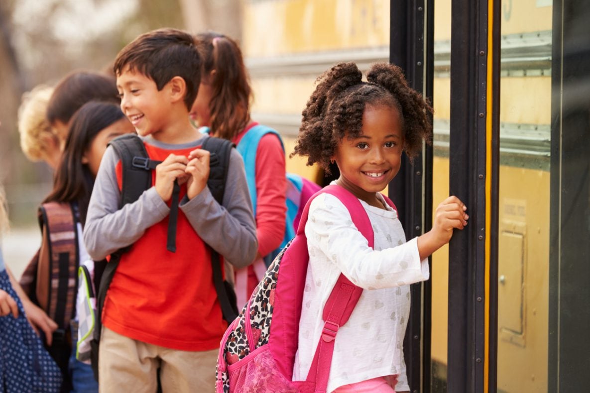 Elementary school girl at the front of the school bus queue