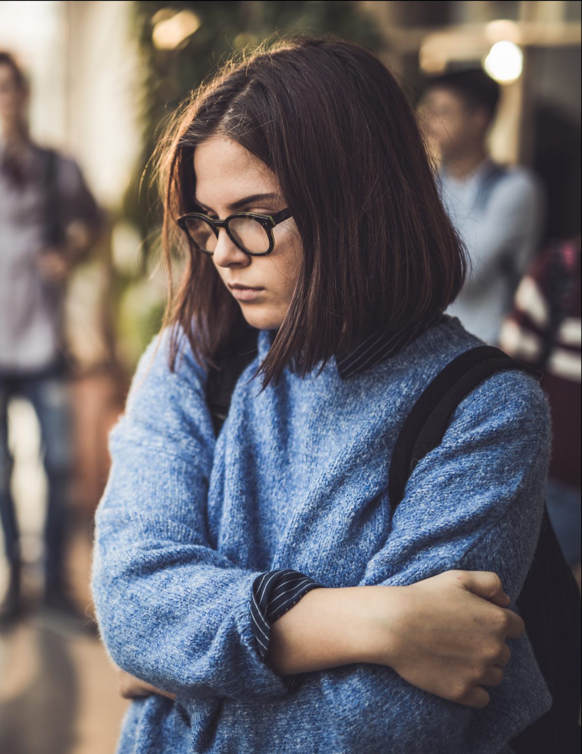 Sad student feeling isolated in a school hallway