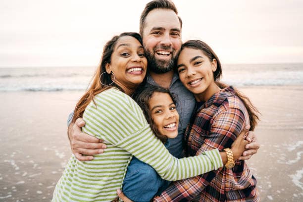 Smiling parents with two children on the beach