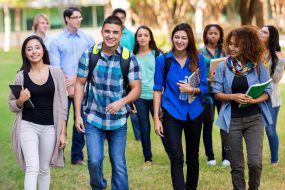 Diverse group of college students walking on beautiful campus