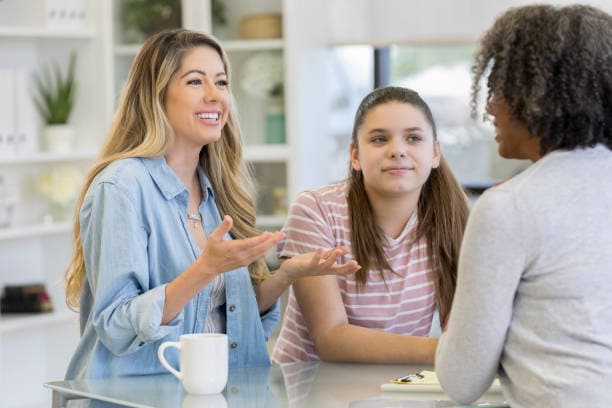 Teenage girl and her mom talk with school counselor