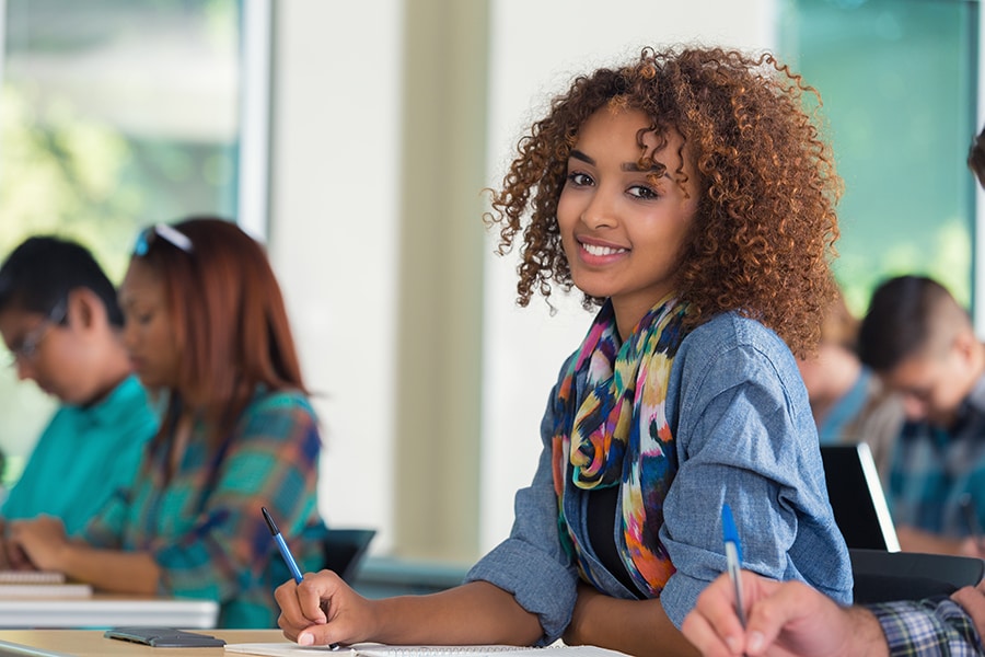 Beautiful African American female teenage college student in classroom