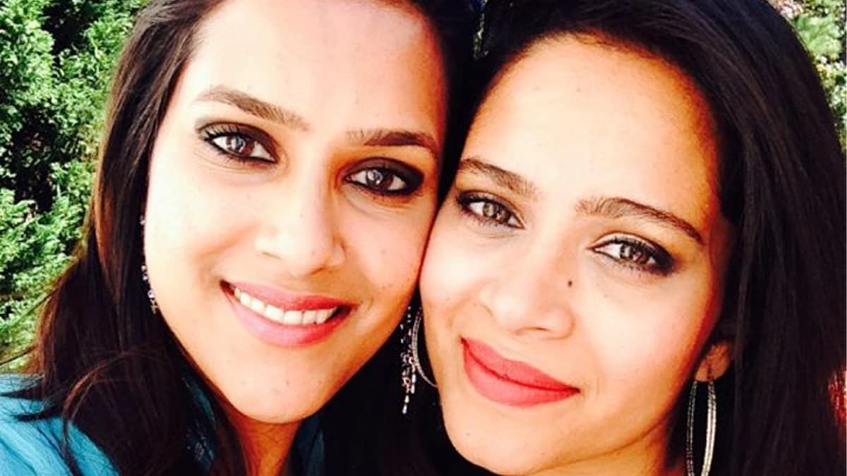 Two sisters smile for the camera while taking a self-portrait outdoors