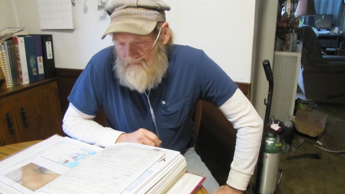 Man with oxygen tank looking at a book