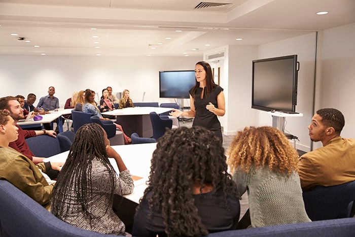 Teacher addresses adult students in a classroom