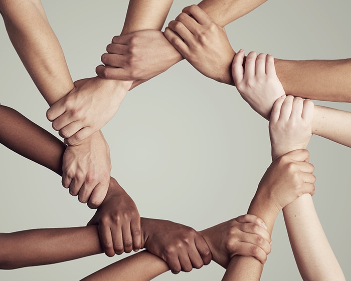 photo of a ring of hands each holding the next