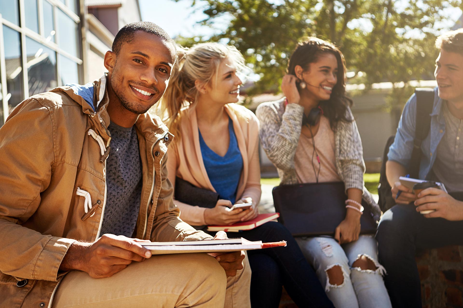 Portrait of a student studying outside on campus with his classmates