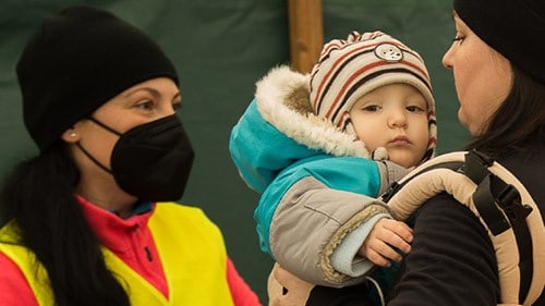 Relief worker assisting a family at a shelter.