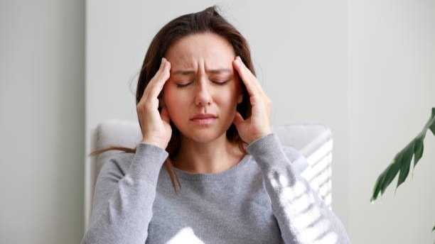 Woman holding her head in pain