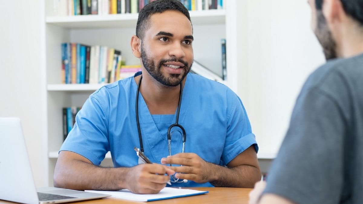 Young male doctor talking with patient.