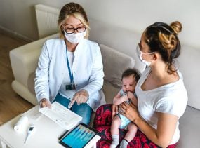 Doctor talking about test results with a mother and baby.