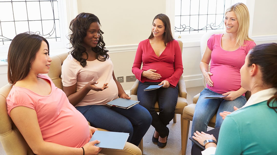 A group of pregnant in a meeting having a discussion.