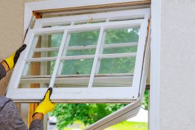 A person wearing gloves holding a new window.